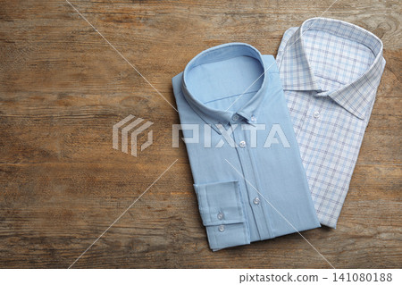 Stylish male shirts on wooden background, flat lay. Space for text Stylish male shirts on wooden background, flat lay. Space for text 141080188