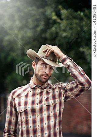 Man, portrait and outdoor cowboy style, western culture and countryside ranch in Texas. Male person, hat and flannel fashion for farmer aesthetic, nature and plaid trend by trees or outside bush Man, portrait and outdoor cowboy style, western culture and countryside ranch in Texas. Male person, hat and flannel fashion for farmer aesthetic, nature and plaid trend by trees or outside bush 141080481