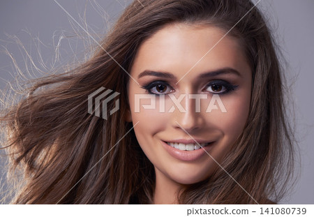 Haircare, portrait and happy woman in studio for salon, shampoo treatment and glow on isolated grey background. Closeup, smile and face of female model with natural cosmetics, hairstyle and volume Haircare, portrait and happy woman in studio for salon, shampoo treatment and glow on isolated grey background. Closeup, smile and face of female model with natural cosmetics, hairstyle and volume 141080739