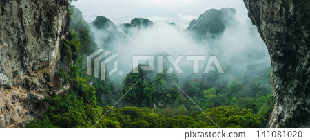 Breathtaking View from a Cave Overlooking Misty Limestone Mountains for Eco-Tourism Breathtaking View from a Cave Overlooking Misty Limestone Mountains for Eco-Tourism 141081020