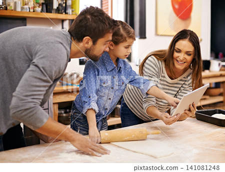 Family, cooking and learning in kitchen with tablet for recipe, guide and parents reading with child in home. Baking, mom and dad with girl helping to meal prep and talking about pizza and dinner Family, cooking and learning in kitchen with tablet for recipe, guide and parents reading with child in home. Baking, mom and dad with girl helping to meal prep and talking about pizza and dinner 141081248