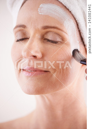 Mature woman, face mask and brush in studio for skincare or anti aging on self care, wellness and fresh skin. Closeup, female person and glow with smile or happy for facial and beauty or luxury Mature woman, face mask and brush in studio for skincare or anti aging on self care, wellness and fresh skin. Closeup, female person and glow with smile or happy for facial and beauty or luxury 141081441
