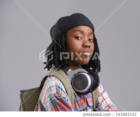 Attitude, headphones and portrait of child on gray background with headphones for song, audio and radio. Fashion, school and young African boy with bag in trendy style, clothes and outfit in studio Attitude, headphones and portrait of child on gray background with headphones for song, audio and radio. Fashion, school and young African boy with bag in trendy style, clothes and outfit in studio 141081532
