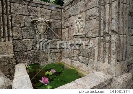 Ancient Roman Style Fountain with Stone Mask and Water Lily 141081574