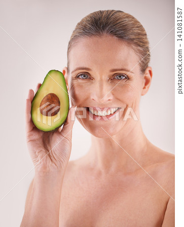 Beauty, avocado and portrait of woman in studio for health, wellness or natural facial routine. Smile, skincare and mature person with organic fruit for face dermatology treatment by white background 141081587