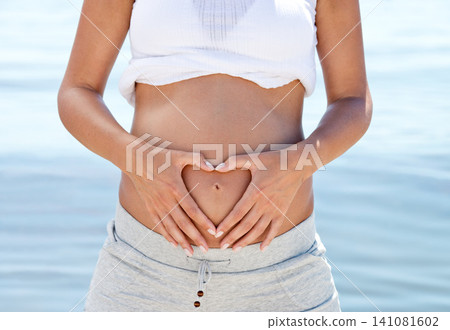Pregnant woman, mom and heart hands on belly at beach, love and family with wellness, self care and ocean fresh air. Health, pregnancy and motherhood with maternity, prenatal and baby bump outdoor Pregnant woman, mom and heart hands on belly at beach, love and family with wellness, self care and ocean fresh air. Health, pregnancy and motherhood with maternity, prenatal and baby bump outdoor 141081602