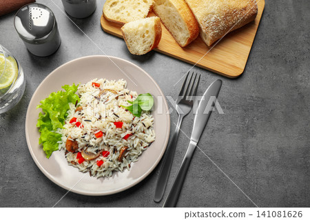 Delicious rice pilaf with mushrooms served on grey table, flat lay Delicious rice pilaf with mushrooms served on grey table, flat lay 141081626