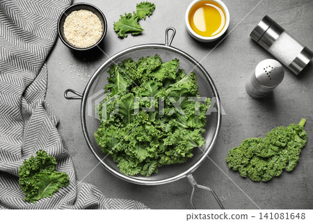 Raw cabbage leaves on grey table, flat lay. Preparing kale chips Raw cabbage leaves on grey table, flat lay. Preparing kale chips 141081648