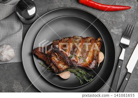 Tasty grilled ribs served on grey table, flat lay Tasty grilled ribs served on grey table, flat lay 141081655