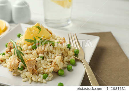 Delicious chicken risotto with lemon on table, closeup Delicious chicken risotto with lemon on table, closeup 141081681