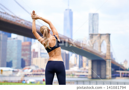 Woman, stretching back for workout in city for fitness or exercise, physical health and stress relief. Girl active to warm up muscle, cardio and training for sports runner or athlete in New York. Woman, stretching back for workout in city for fitness or exercise, physical health and stress relief. Girl active to warm up muscle, cardio and training for sports runner or athlete in New York. 141081794