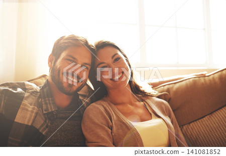 Love, happy and portrait of couple on sofa for bonding, loving relationship and relax together in home. Marriage, morning and man and woman on couch with smile, embrace and hugging in living room Love, happy and portrait of couple on sofa for bonding, loving relationship and relax together in home. Marriage, morning and man and woman on couch with smile, embrace and hugging in living room 141081852