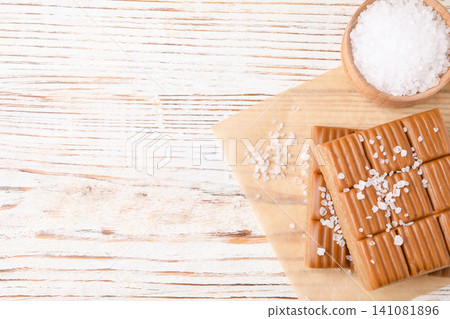 Salted caramel on white wooden table, top view. Space for text 141081896