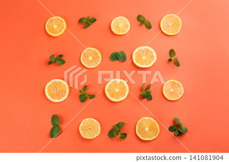 Lemonade layout with juicy lemon slices and mint on coral background, top view Lemonade layout with juicy lemon slices and mint on coral background, top view 141081904