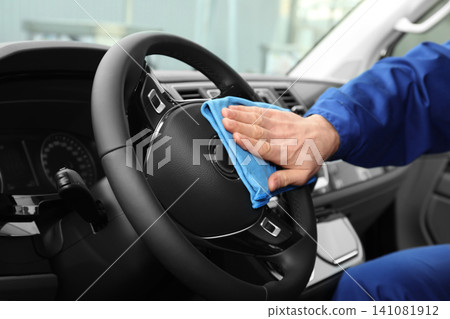 Car wash worker cleaning automobile interior, closeup Car wash worker cleaning automobile interior, closeup 141081912