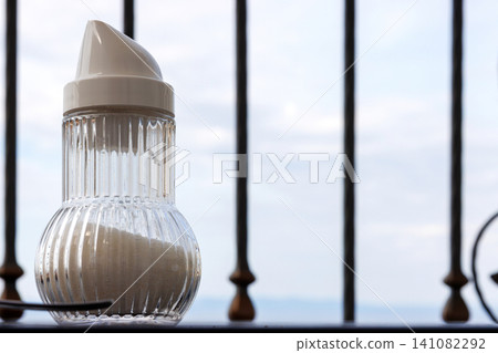Glass sugar shaker on a balcony breakfast table with Adriatic sea view in Makarska, Croatia 141082292