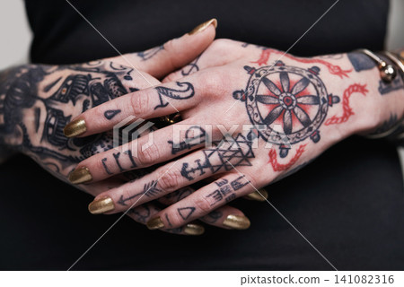 Person, hands and tattoo with nails for polish, creative and ink for design, picture and symbol on closeup. Art, bold and cool for red and statement with varnish for funky, trendy and vibrant Person, hands and tattoo with nails for polish, creative and ink for design, picture and symbol on closeup. Art, bold and cool for red and statement with varnish for funky, trendy and vibrant 141082316