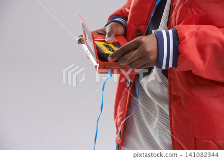 Hands, music and mix tape with player for cassette, hip hop and aesthetic for youth with culture. Retro, vintage and audio from track of mini boombox for kid or child in studio with grey background 141082344