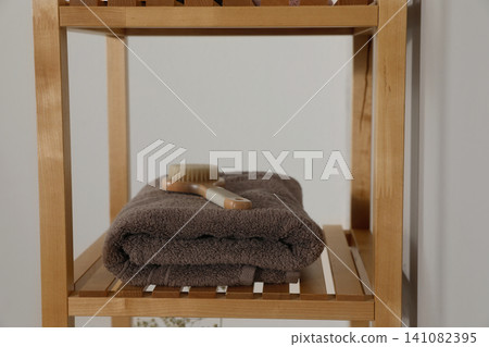 Shelving unit with toiletries near light wall indoors. Bathroom interior element Shelving unit with toiletries near light wall indoors. Bathroom interior element 141082395