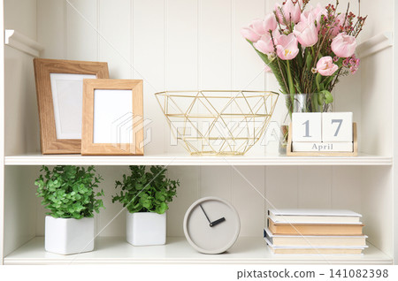 White shelving unit with plants and different decorative stuff White shelving unit with plants and different decorative stuff 141082398