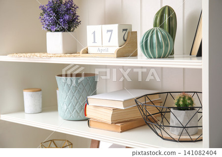 White shelving unit with books and different decorative stuff White shelving unit with books and different decorative stuff 141082404