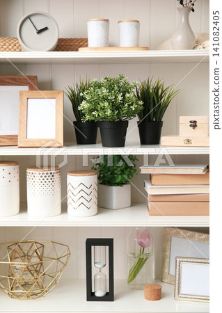 White shelving unit with plants and different decorative stuff White shelving unit with plants and different decorative stuff 141082405