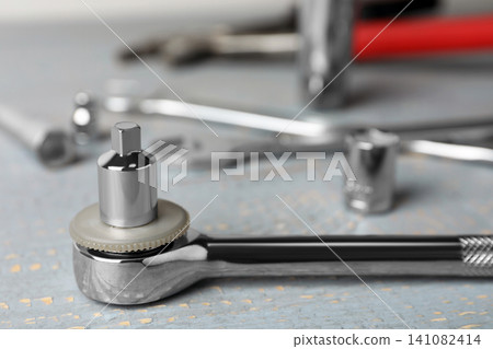 Auto mechanic's tool on grey wooden table, closeup Auto mechanic's tool on grey wooden table, closeup 141082414