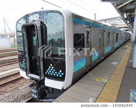一列正在進行試運行的新型通勤列車和一個車站月台。 一列正在進行試運行的新型通勤列車和一個車站月台。 141082445