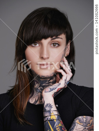Woman, portrait and stylist with tattoo for facial treatment, style or body art on a gray studio background. Face of female person, young model or smile for design, creativity or cool beauty artist Woman, portrait and stylist with tattoo for facial treatment, style or body art on a gray studio background. Face of female person, young model or smile for design, creativity or cool beauty artist 141082666
