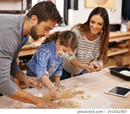 Pizza, dough and parents with child in kitchen and tablet for recipe, guide and learning together. Family, cooking and girl help with rolling pin and baking with dad and mom in home for dinner Pizza, dough and parents with child in kitchen and tablet for recipe, guide and learning together. Family, cooking and girl help with rolling pin and baking with dad and mom in home for dinner 141082987