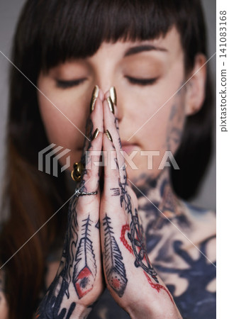 Woman, tattoo and pray for ink, faith and creative for belief, religion and spiritual for design on closeup. Young person and eyes closed for zen, namaste and nails for varnish and symbol for edgy Woman, tattoo and pray for ink, faith and creative for belief, religion and spiritual for design on closeup. Young person and eyes closed for zen, namaste and nails for varnish and symbol for edgy 141083168