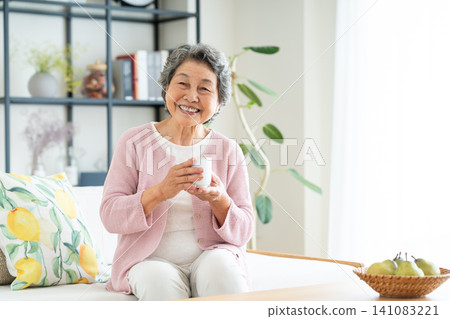 Senior woman relaxing in the living room Senior woman relaxing in the living room 141083221