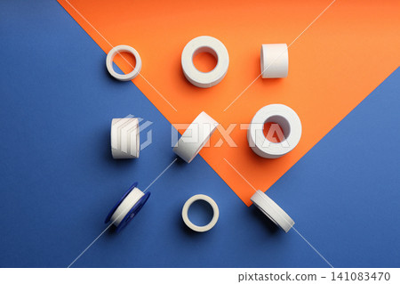 Sticking plaster rolls on color background, flat lay 141083470