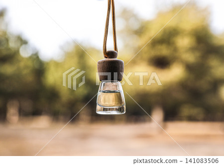 Car air freshener hanging on blurred view, closeup Car air freshener hanging on blurred view, closeup 141083506