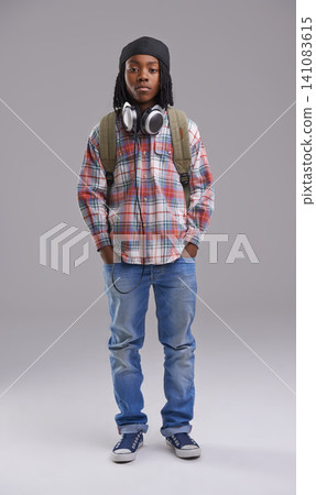 Headphones, fashion and portrait of child on gray background for listening to song, audio and radio. Student, school and young African boy with bag in trendy style, clothes and outfit in studio Headphones, fashion and portrait of child on gray background for listening to song, audio and radio. Student, school and young African boy with bag in trendy style, clothes and outfit in studio 141083615