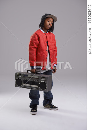 Child, hip hop and portrait with radio for music and dance in a studio with urban clothing. Fashion, African kid and boombox with trendy clothes and youth swag with confidence and grey background 141083642