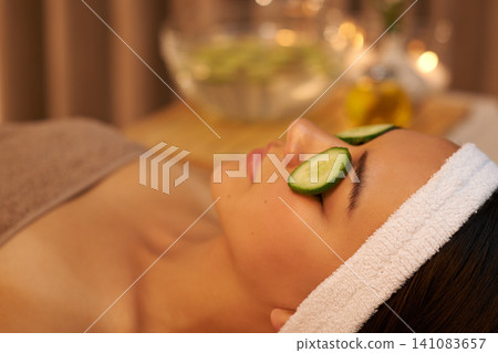 Spa, relax and woman with cucumber on face for skincare massage, peace or wellness. Facial, salon and person with vegetable on eyes in therapy for natural beauty or healthy organic treatment closeup 141083657