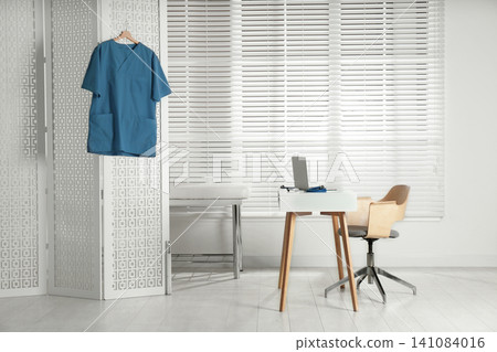 Doctor's office interior with desk and examination couch Doctor's office interior with desk and examination couch 141084016