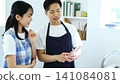 Kitchen: Image of a man and woman thinking up recipes on their smartphones. 141084081