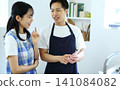 Kitchen: Image of a man and woman thinking up recipes on their smartphones. 141084082