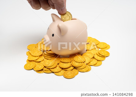 將硬幣放入存錢筒是一種投資和資產累積的方式。 將硬幣放入存錢筒是一種投資和資產累積的方式。 141084298