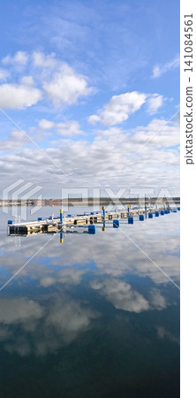 Boat dock, sailboats, blue sky, blue lake, sun, clouds, yacht marina Boat dock, sailboats, blue sky, blue lake, sun, clouds, yacht marina 141084561