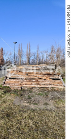 A stack of old logs and firewood piled along a footpath. A stack of old logs and firewood piled along a footpath. 141084562