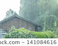 Heavy rain is beating down on an old farmhouse in the countryside. 141084616