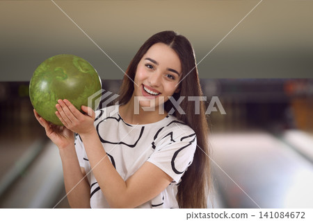 Young woman with ball in bowling club Young woman with ball in bowling club 141084672