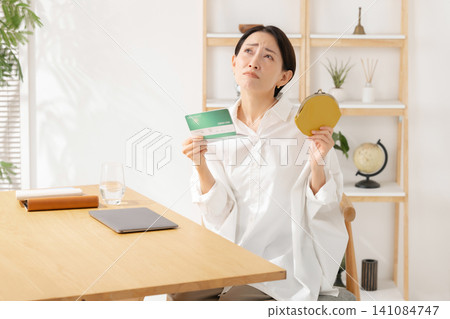 A woman who is worried about looking at her passbook A woman who is worried about looking at her passbook 141084747
