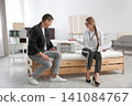 Young saleswoman consulting man in mattress store Young saleswoman consulting man in mattress store 141084767