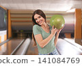 Young woman with ball in bowling club Young woman with ball in bowling club 141084769