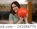 Young woman with ball in bowling club Young woman with ball in bowling club 141084770