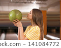 Young woman with ball in bowling club Young woman with ball in bowling club 141084772